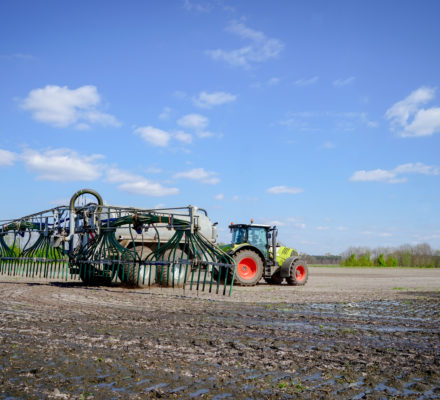 Traktor bringt Gülle auf den Acker