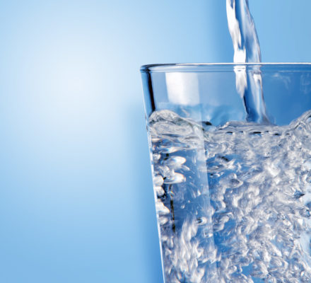 Glas wird mit Wasser befüllt